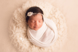 newborn baby girl smiles in a white fur | jana photography North Vancouver bc