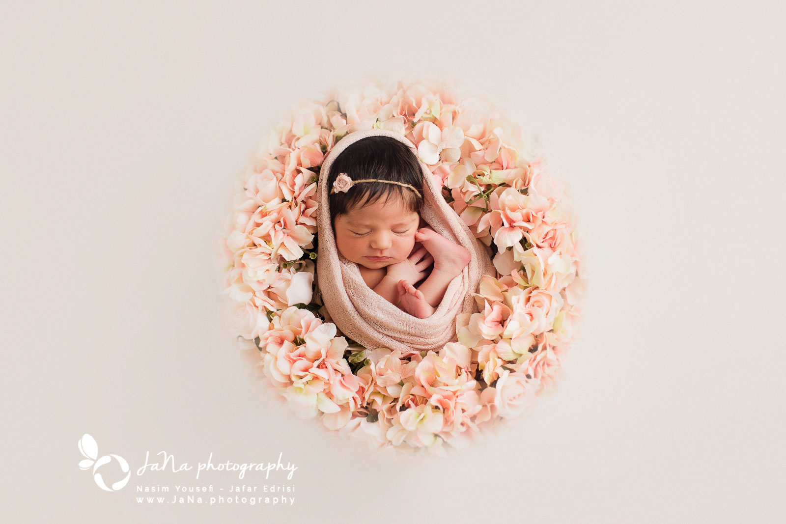 newborn baby girl captured in a flower basket