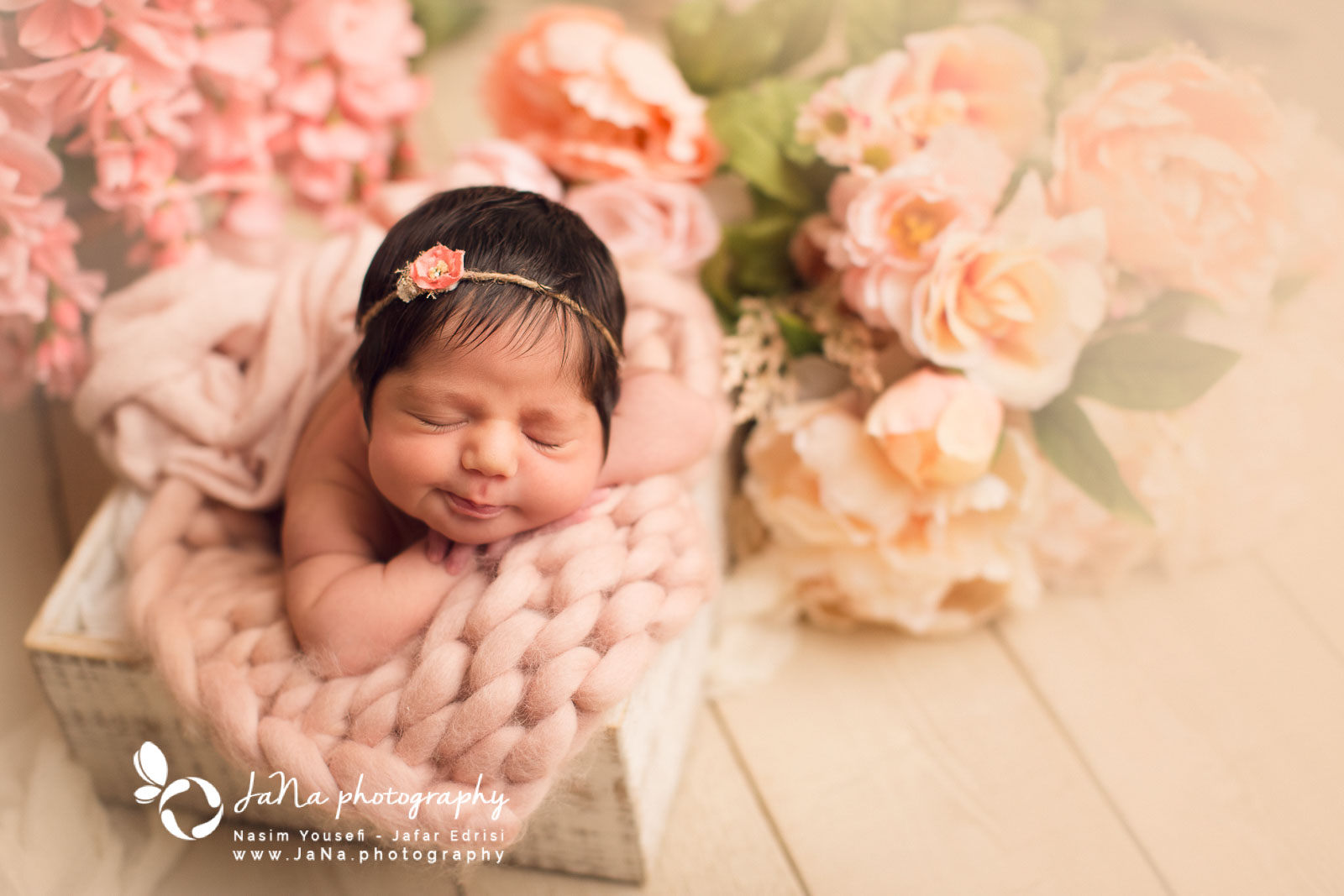 newborn baby girl is sleeping in a white box with flowers