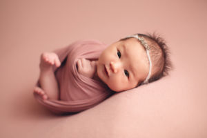 professional-newborn-photography-vancouver, cute baby girl open eyes in a ponk setup