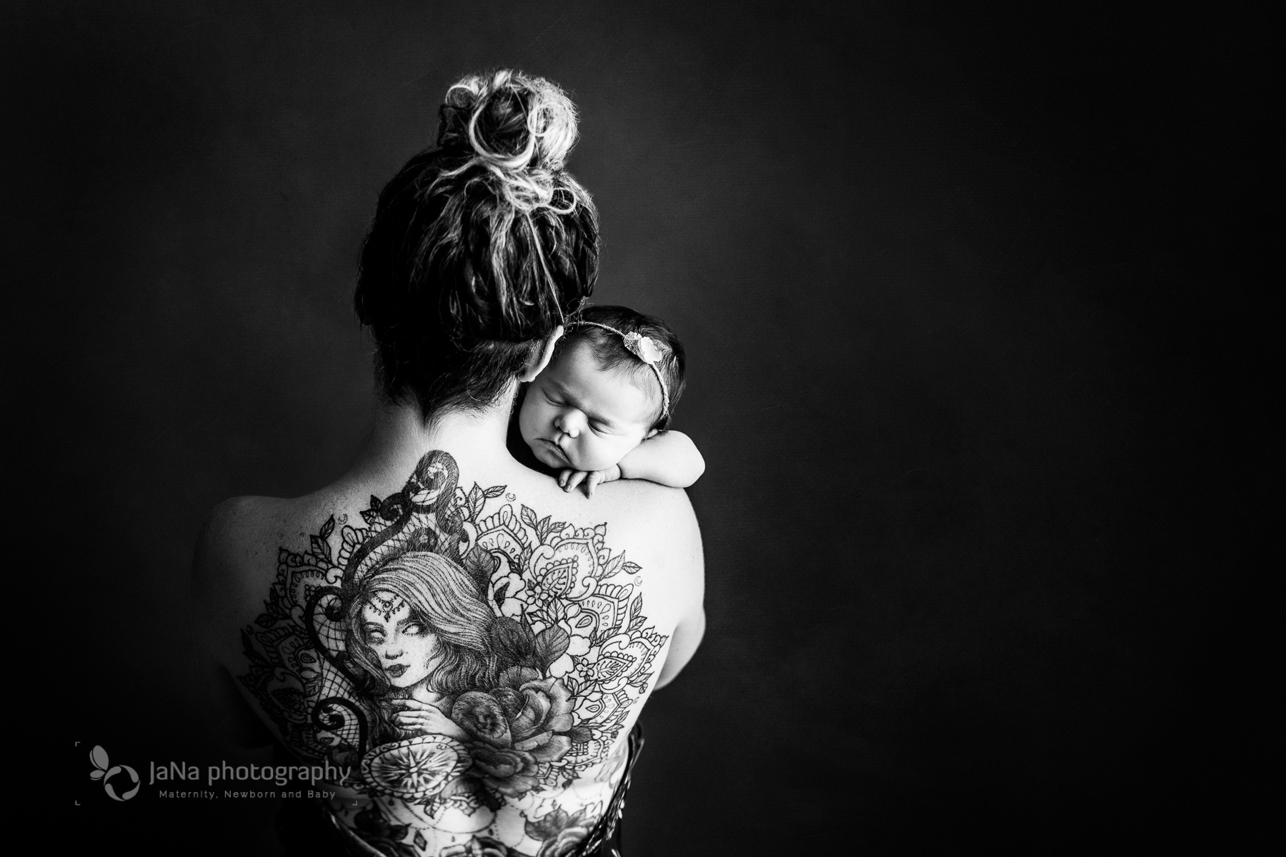 mom has a great tattoo. black and white - baby girl sleeping on her shoulder