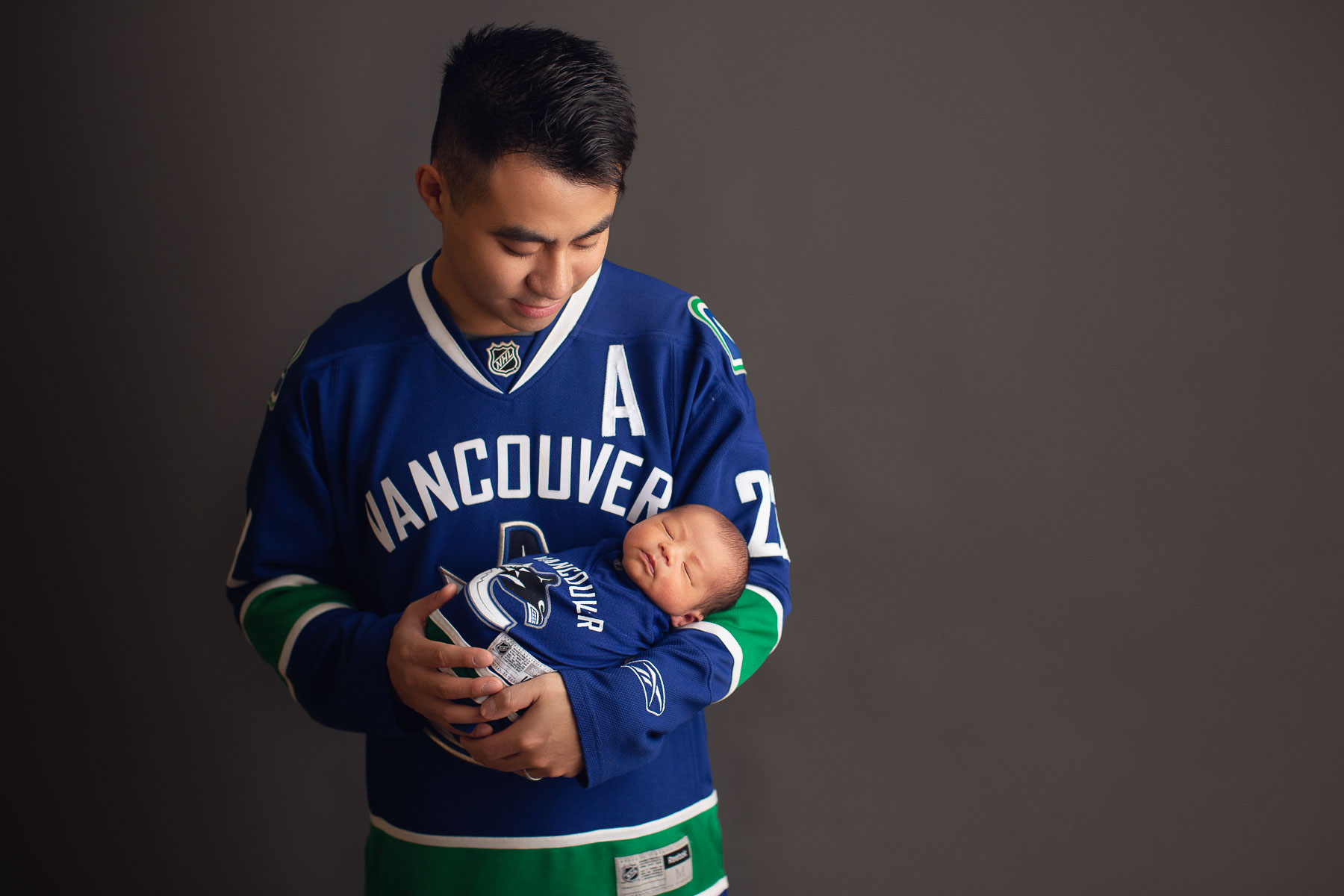 Vancouver Canucks newborn photography - daddy and son Canucks outfit