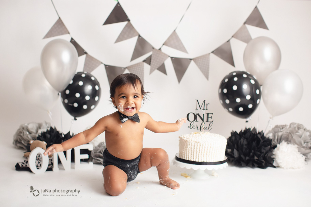 newborn photography with dad's hand - black back ground