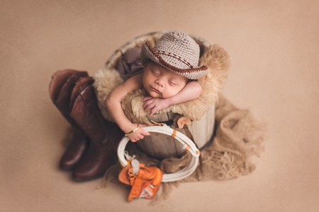 newborn baby boy with a cowboy outfit