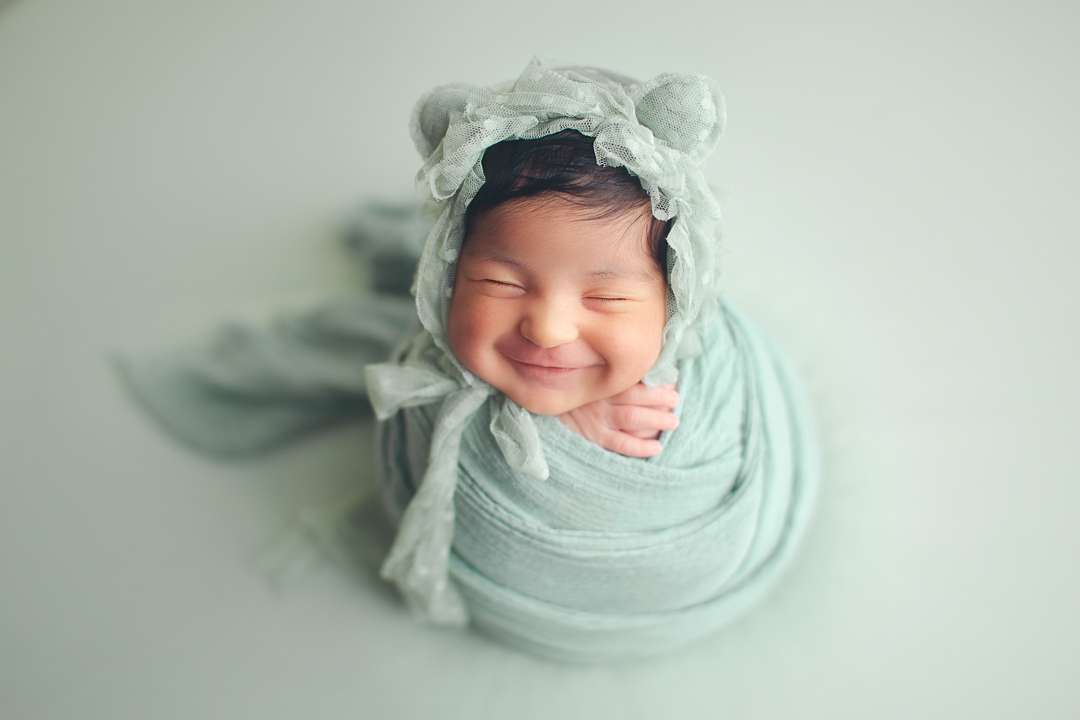 newborn baby girl smiling green setup - hat