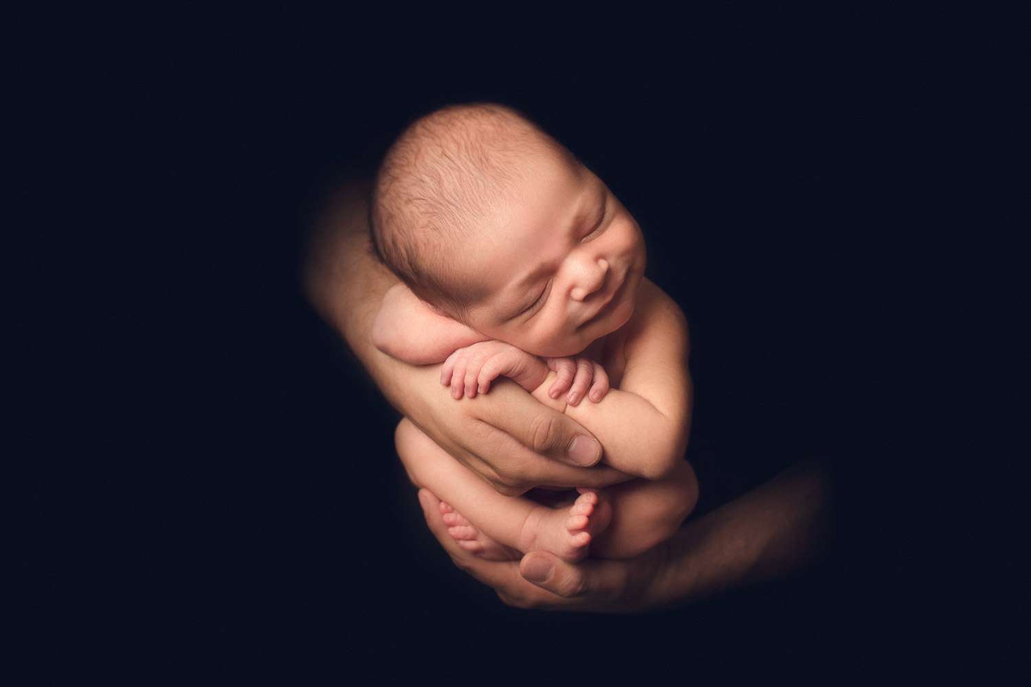 dad's hand holding his boy- black back ground