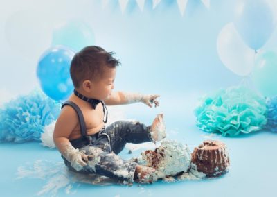 baby boy smashing his cake in a blue setup | jana photography Vancouver bc