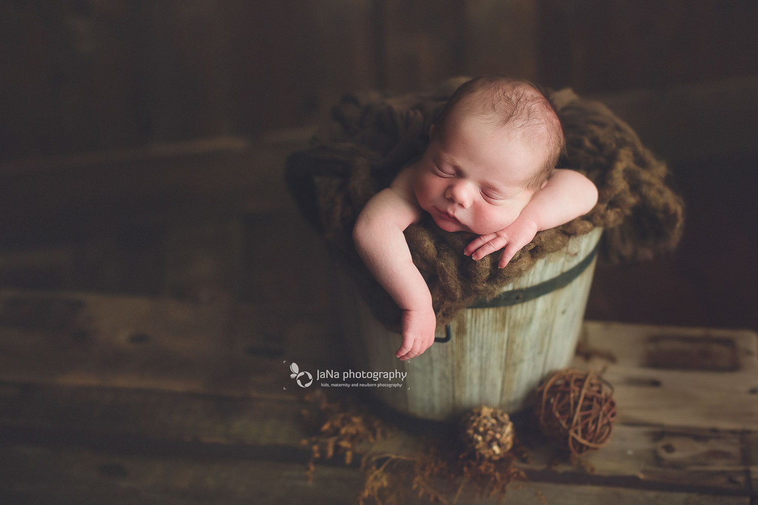 posing newborn babies in a brown bucket - jana photography