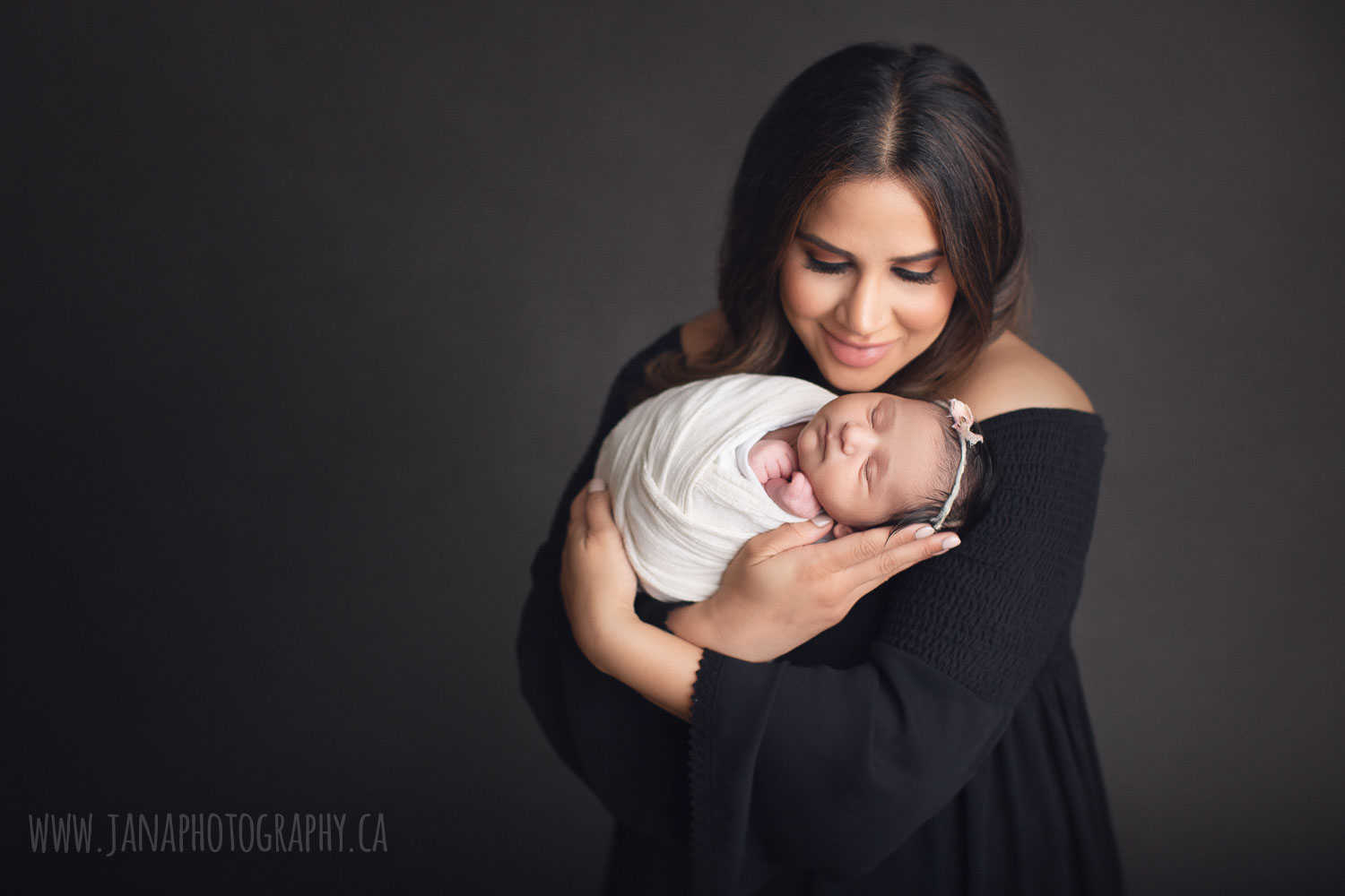 newborn photography vancouver - mom is holding baby girl - grey background