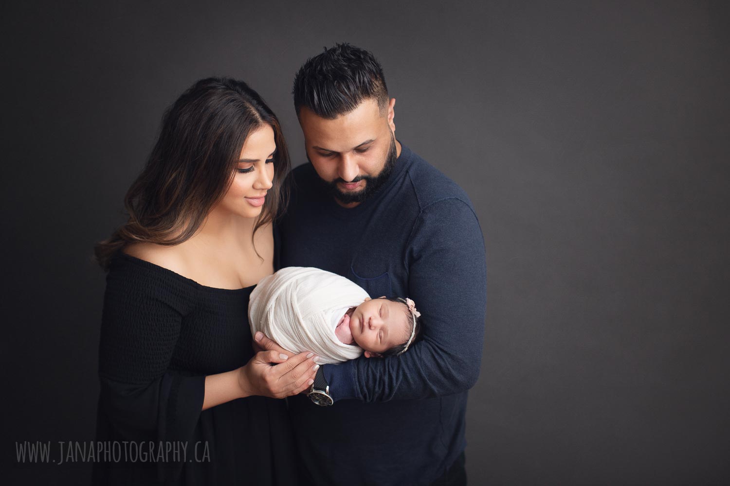 newborn photography - family - dad holding baby girl - grey background
