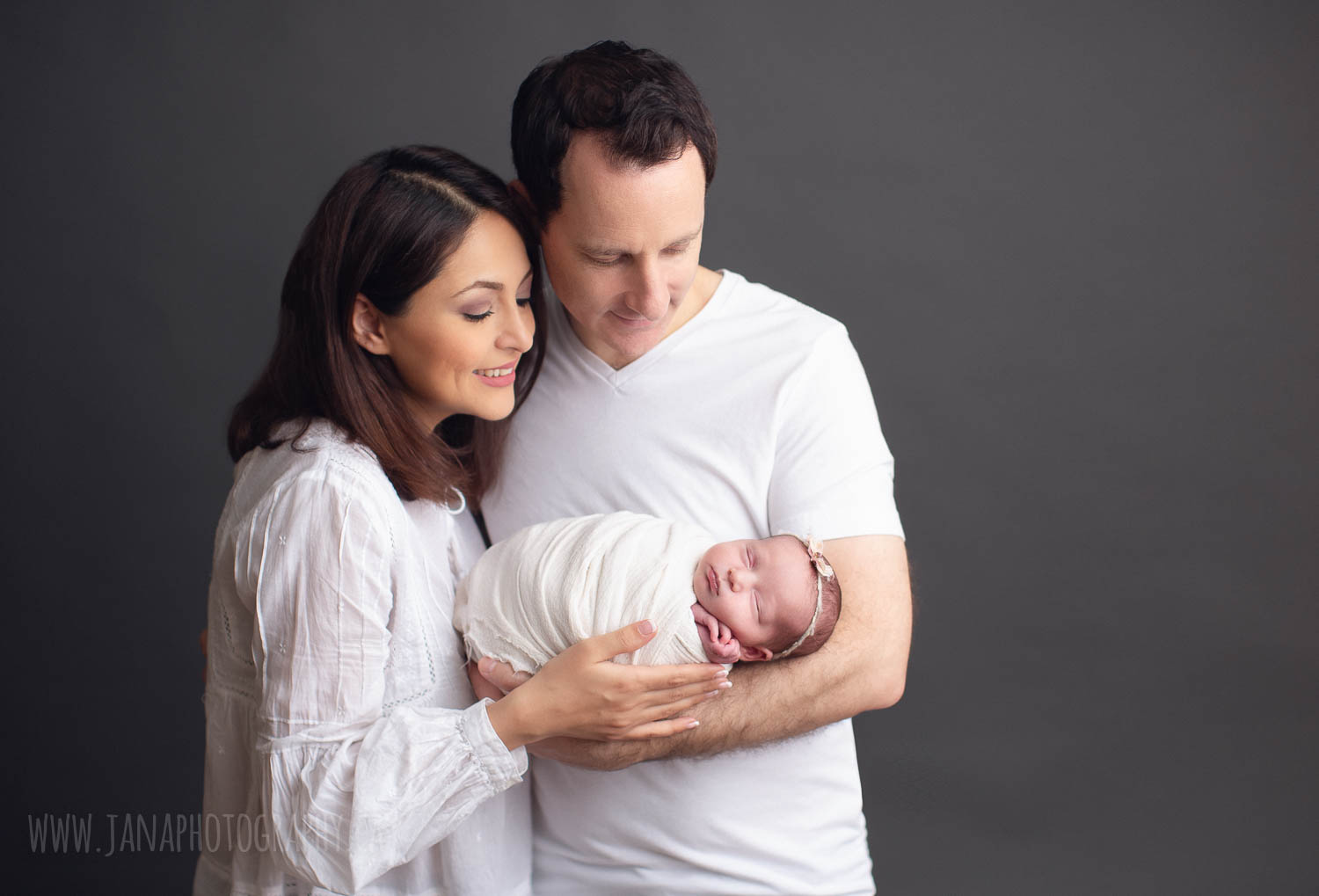 newborn photography - family - dad holding baby girl - grey background