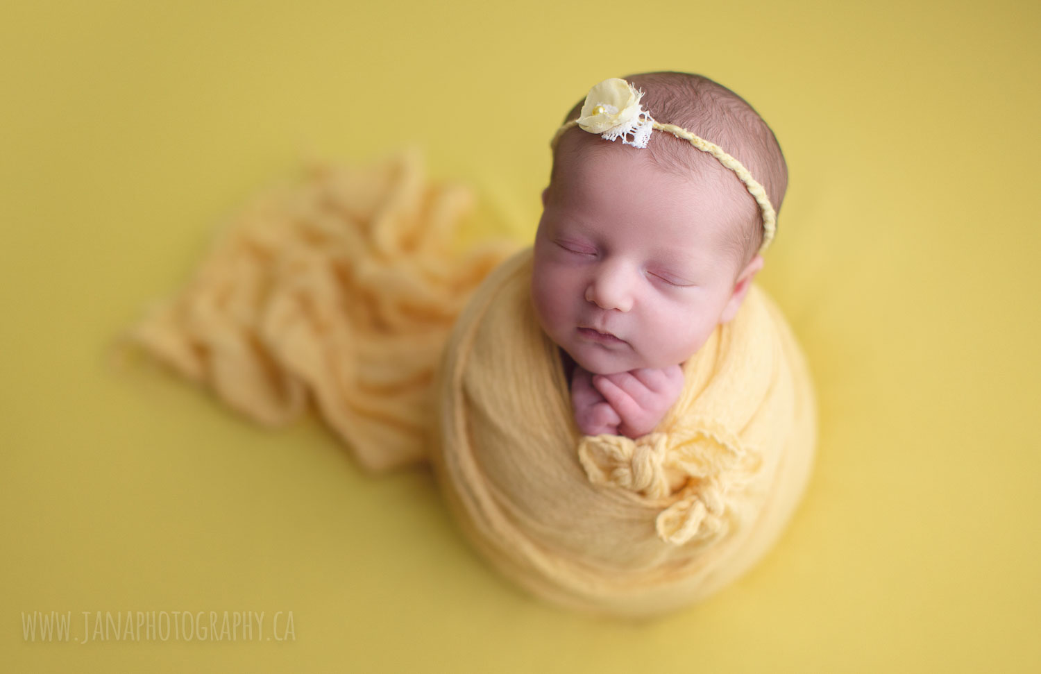 newborn photography - baby girl in a yellow background