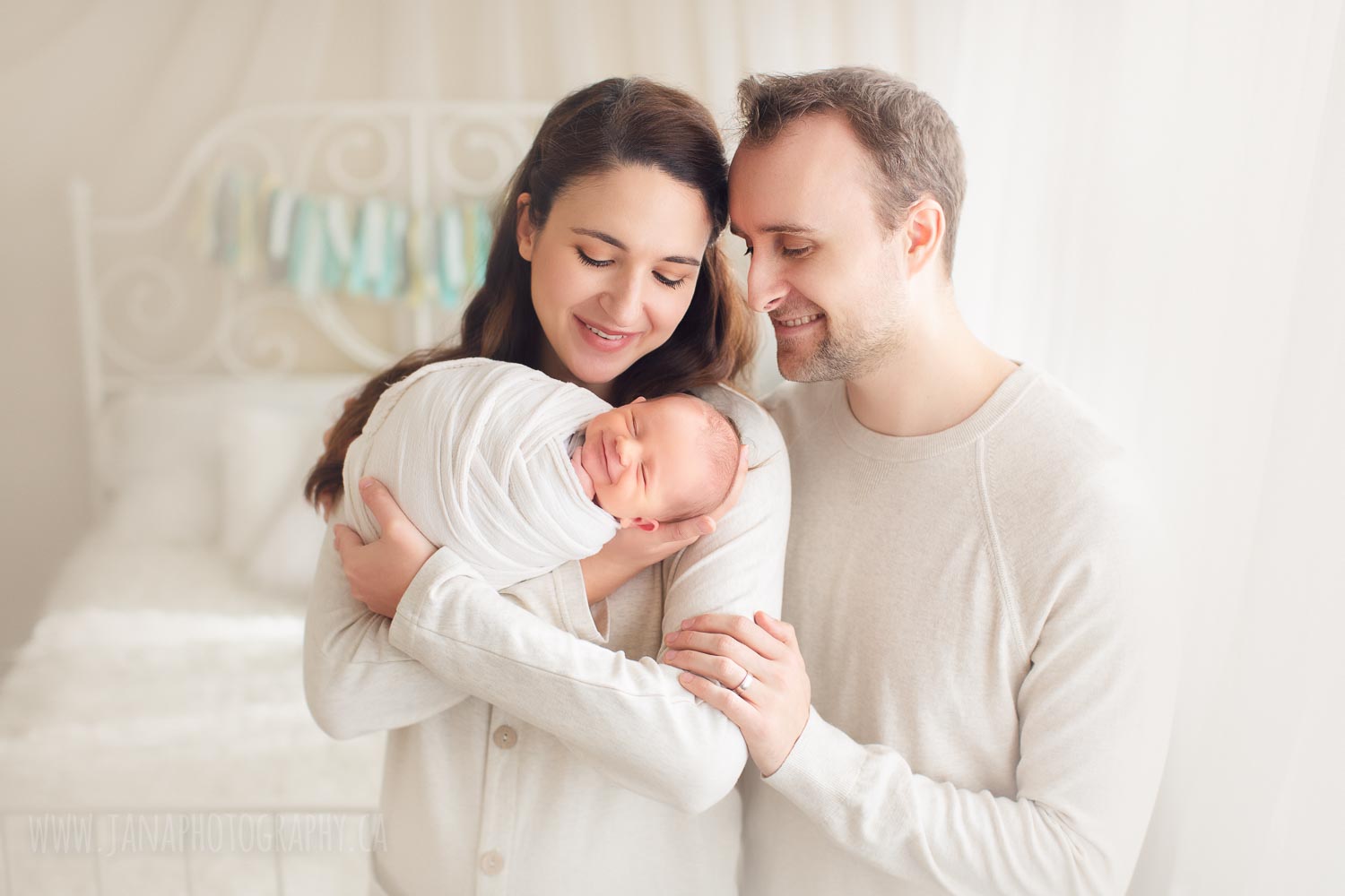 mom and dad holding their newborn baby boy - smile - natural light
