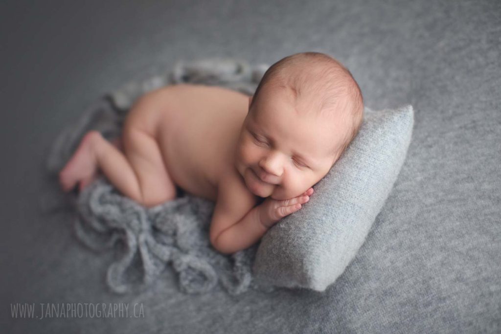 newborn baby boy in a grey background