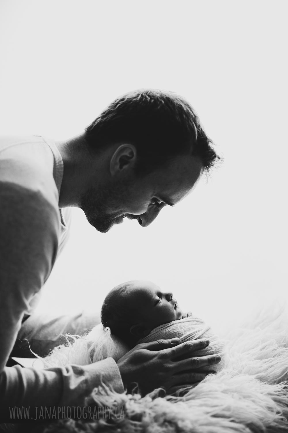 newborn baby boy and his dad in a black and white photo - jana photography