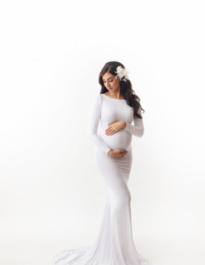 maternity photo with a white dress gown in a white background