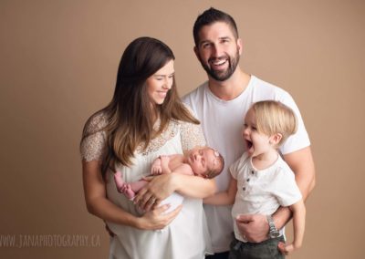 family with big baby boy and newborn girl - photography studio - mocha color background