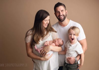 family with big baby boy and newborn girl - photography studio - mocha color background