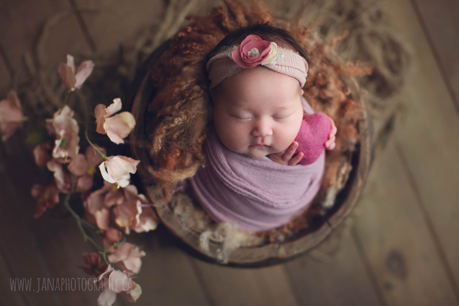 newborn baby girl is holding pink heart - newborn photography vancouver jana