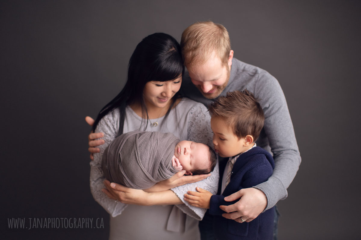 newborn photography experience - family of four in a dark background - jana  