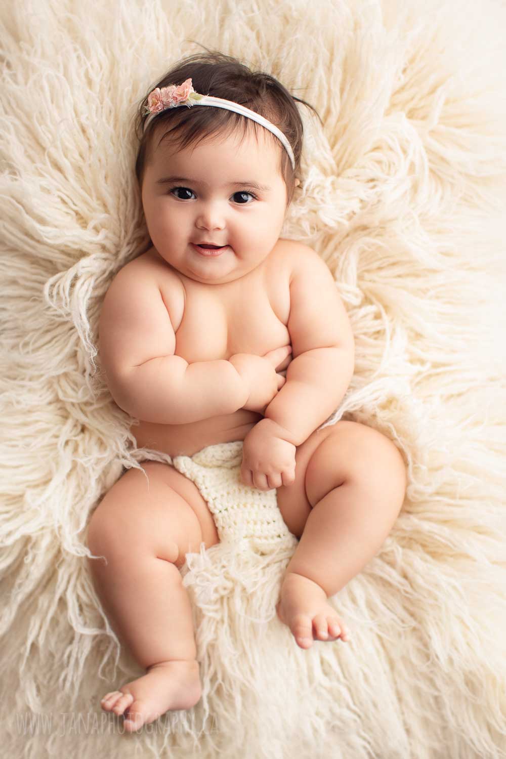 Best time to do a baby photography, Naked baby girl laying on the back looking at the camera