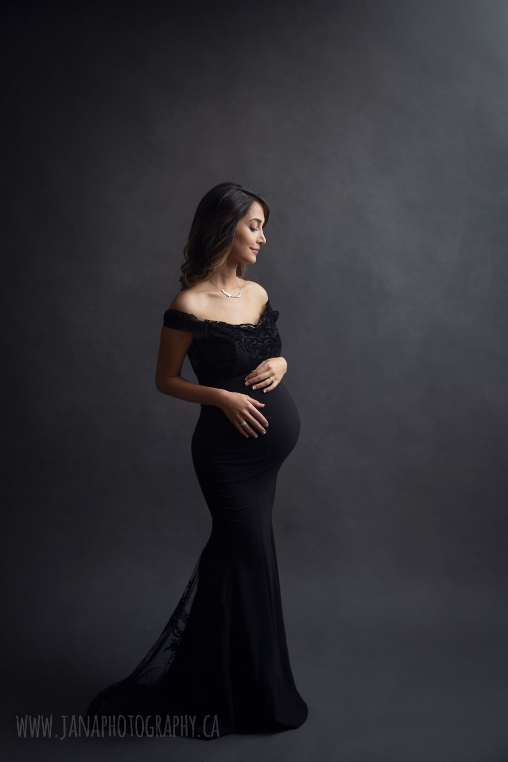 Pregnant woman with black dress in maternity photo black background