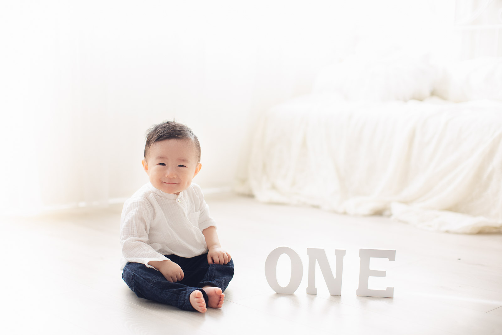 one year old boy in white background sitting on the floor dreamy background