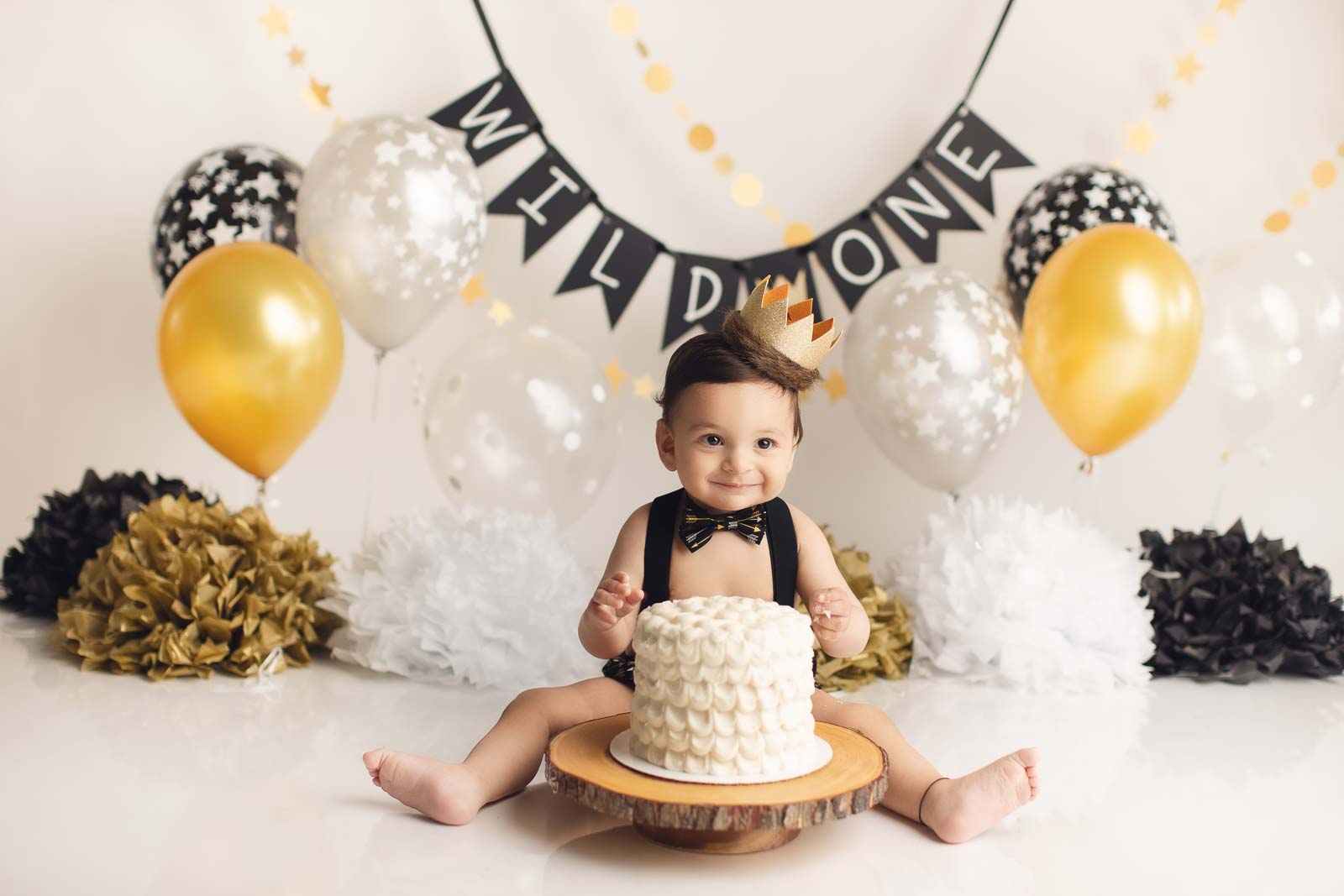 black and gold cake smash setup for boys wild one theme