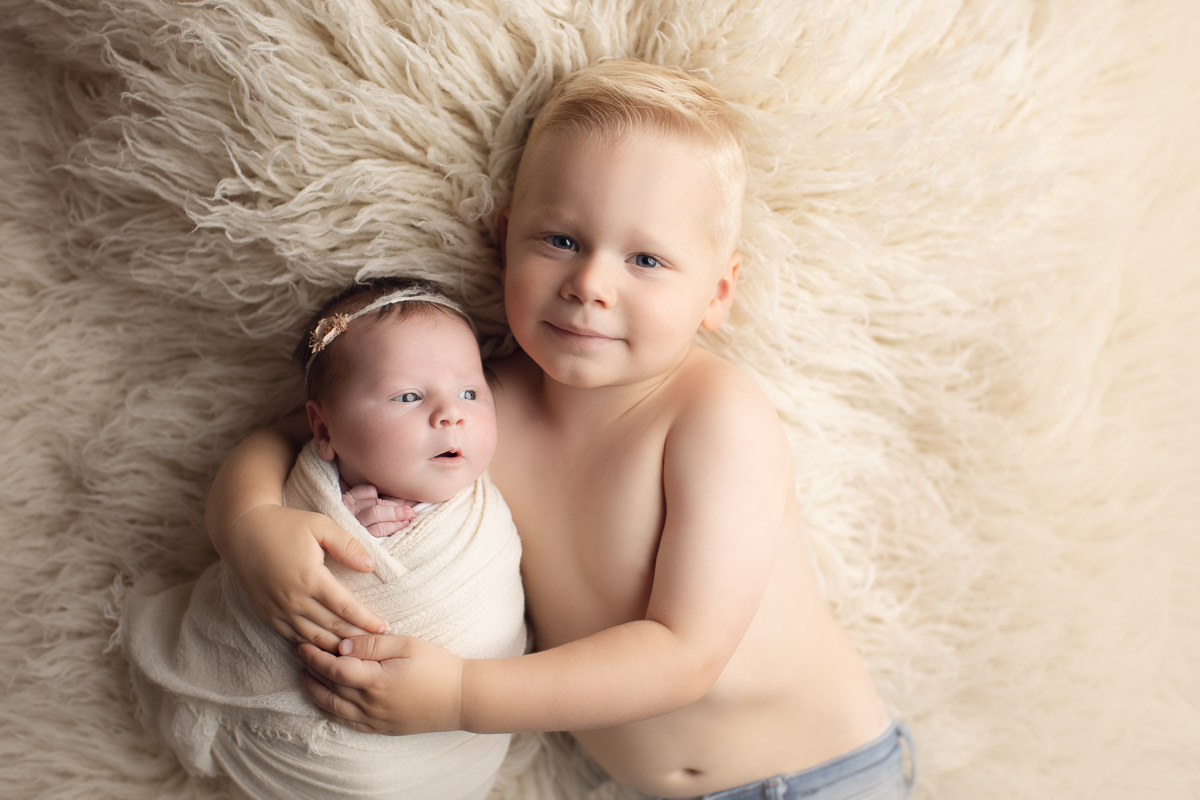 newborn baby girl smiles - hat - pink background