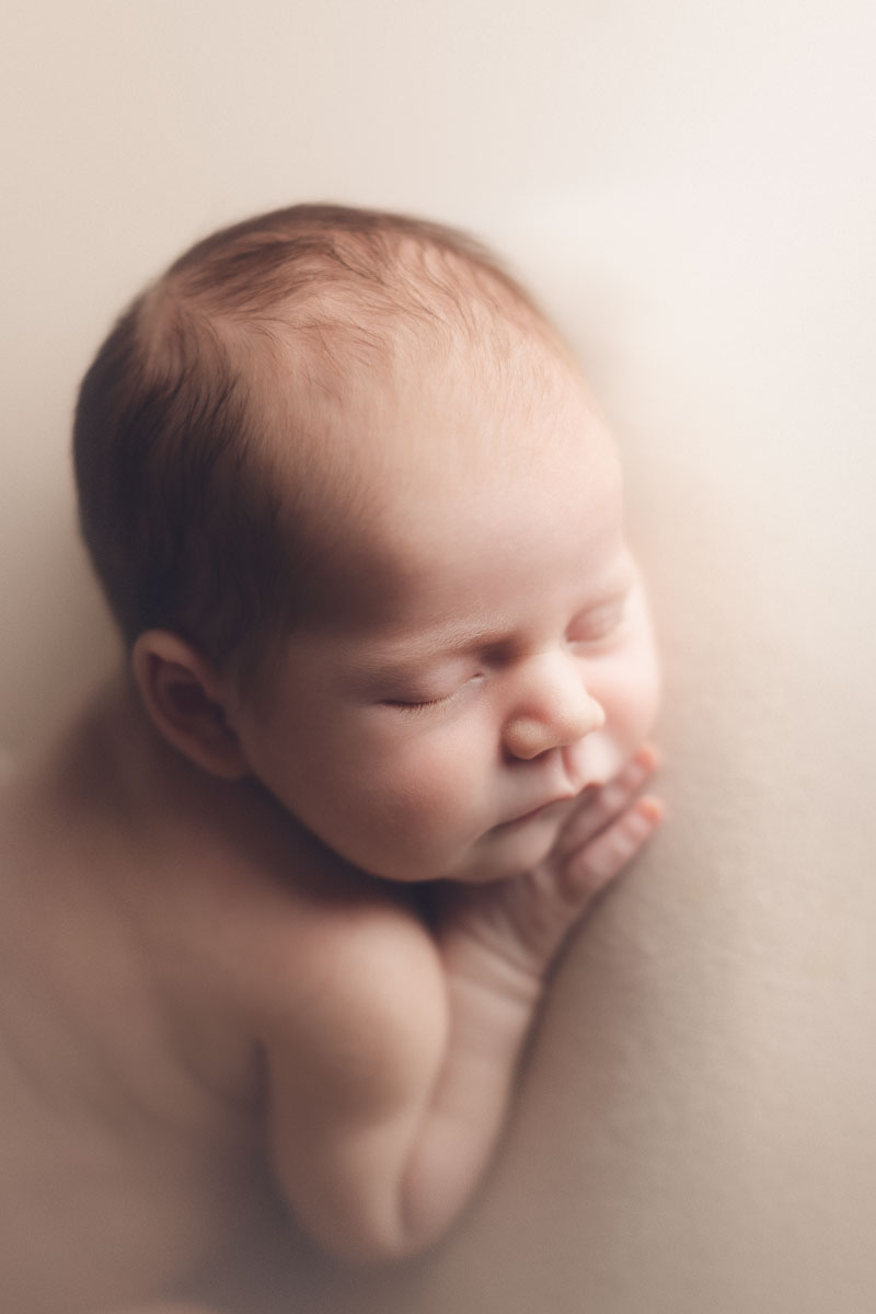 baby girl sleeping on a cream background