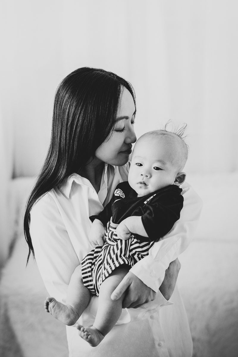 100 days old baby boy with mom kissing