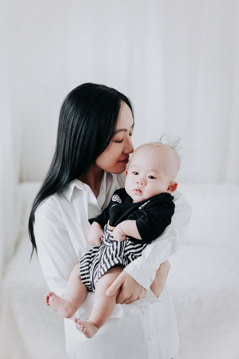 100 days old baby boy with mom kissing