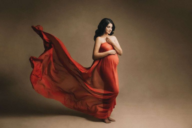 Fine art and dreamy fabric drape for pregnancy in red color in Vancouver maternity photography studio