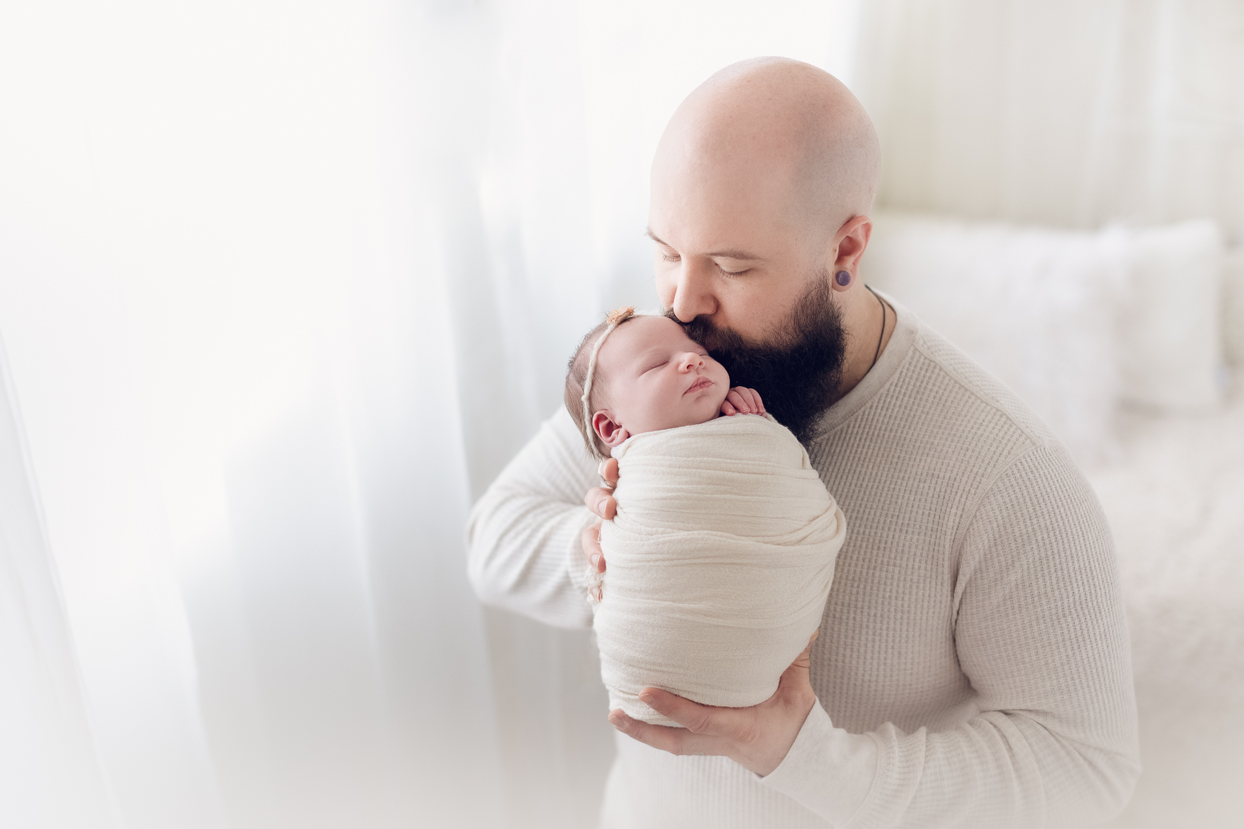 dad holding his newborn baby girl in a natural light studio. newborn photography Vancouver
