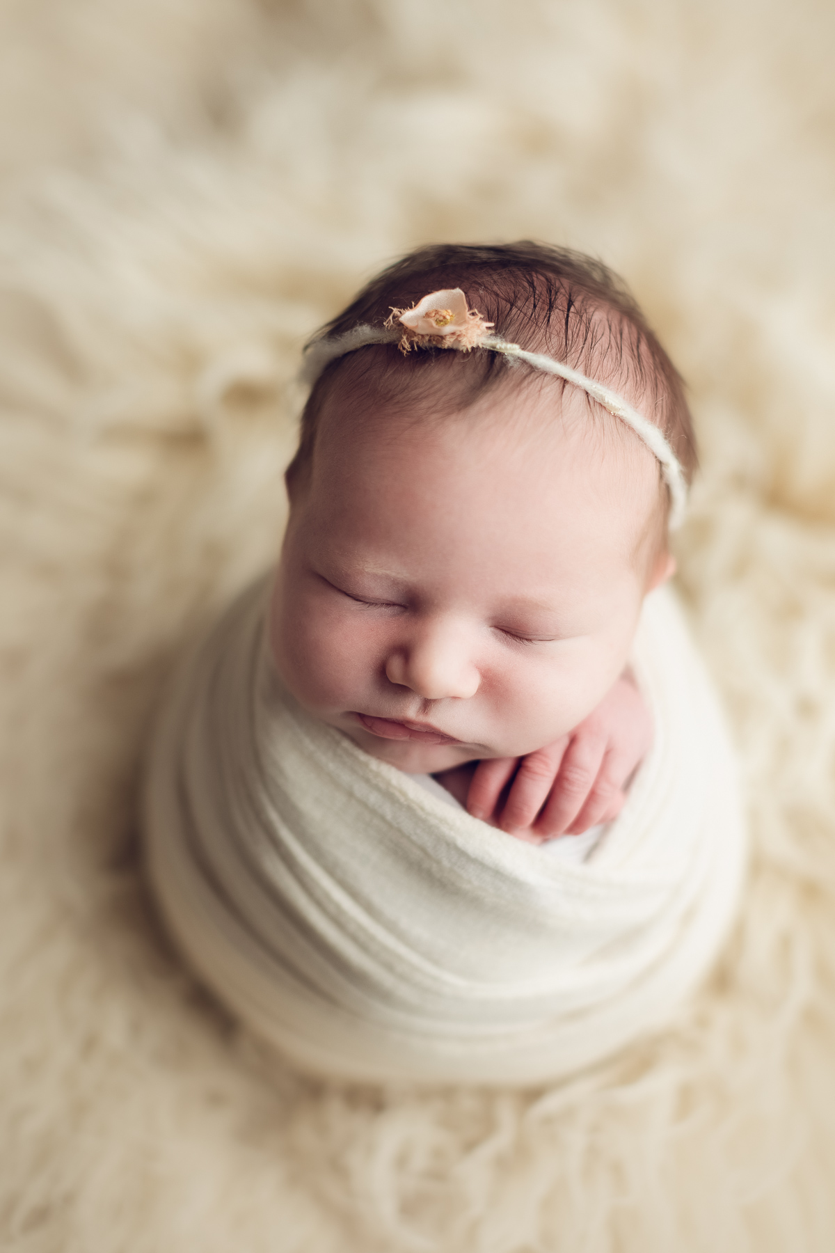 Newborn baby girl in a white wrap - classic package sample