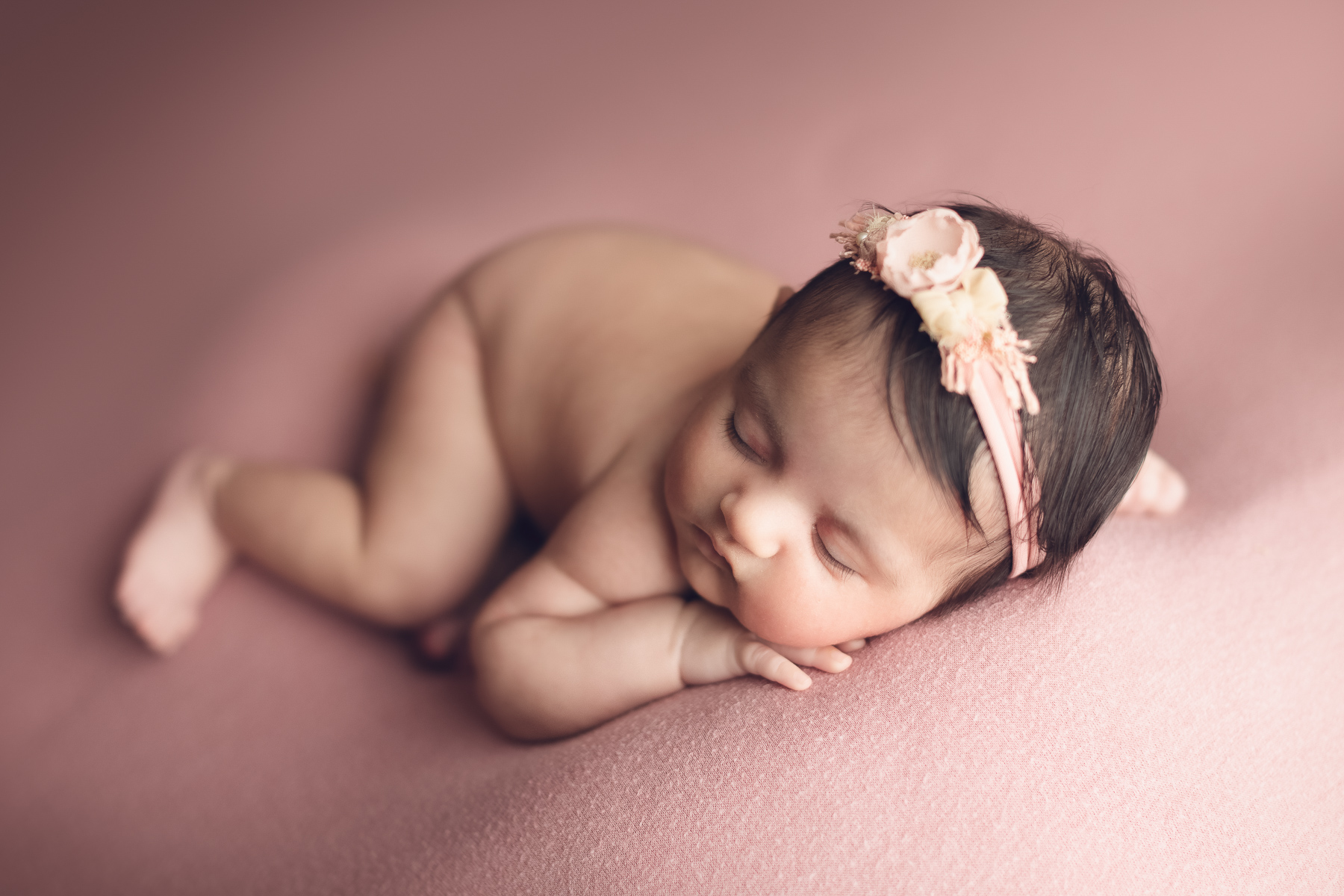 best newborn photographer in Vancouver, surrey and burnaby bc - baby girl sleeping in a pink background