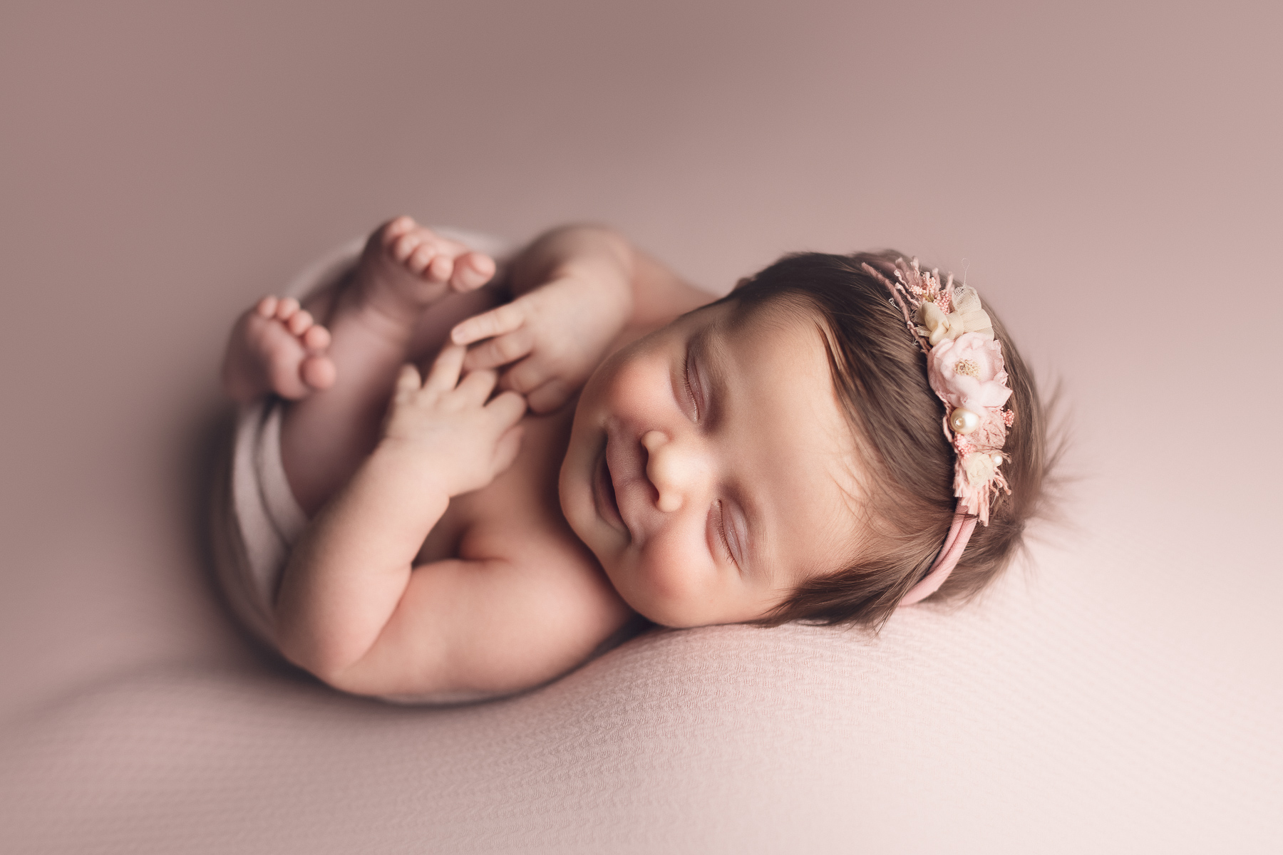 Capturing the Precious Moments of Your Little Angel - baby girl smiling in a pink background