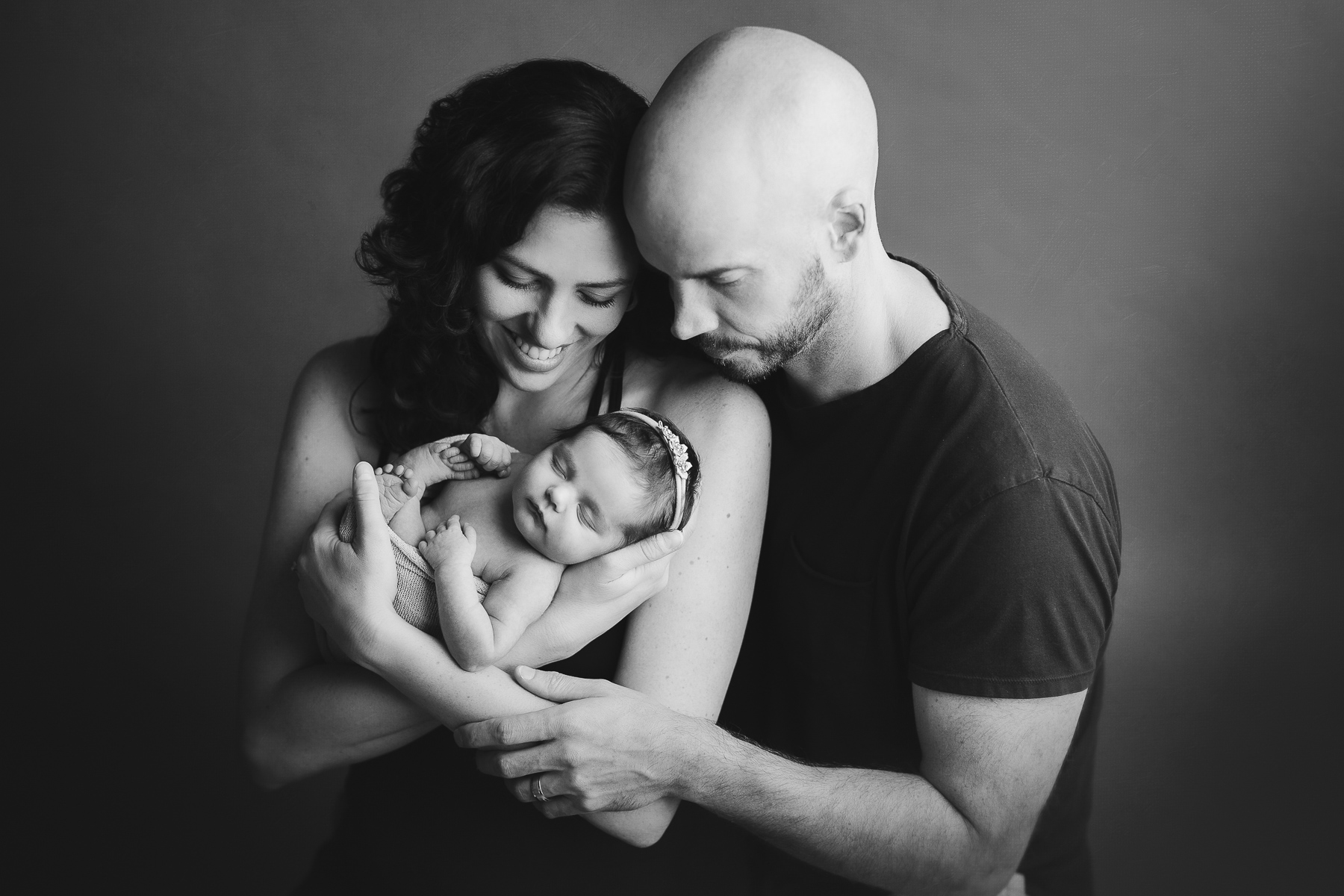 5 reason that newborn photography is important -mom and dad holding newborn black and white
