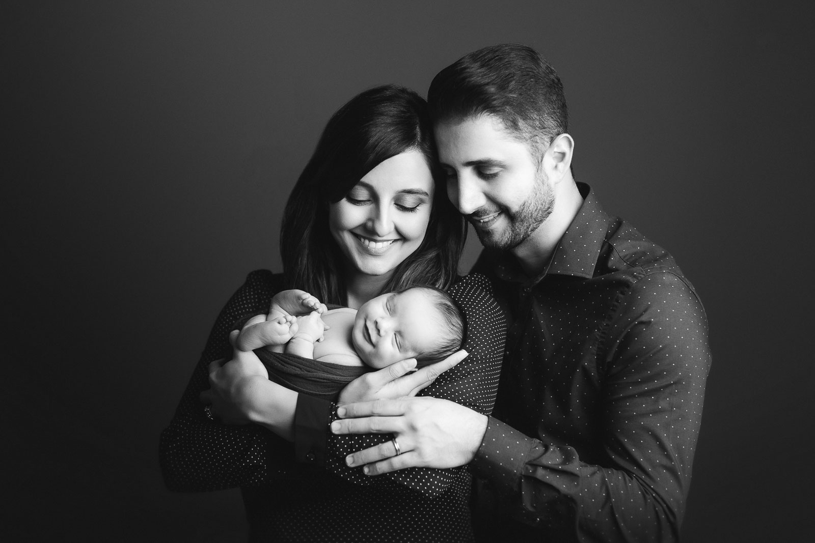newborn baby smiling with mom and dad
