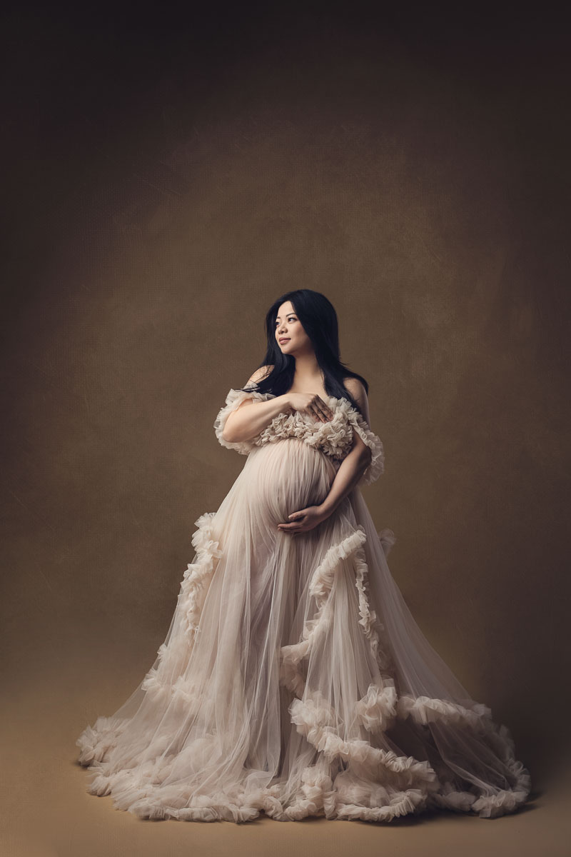maternity photography with cream gown and studio lighting