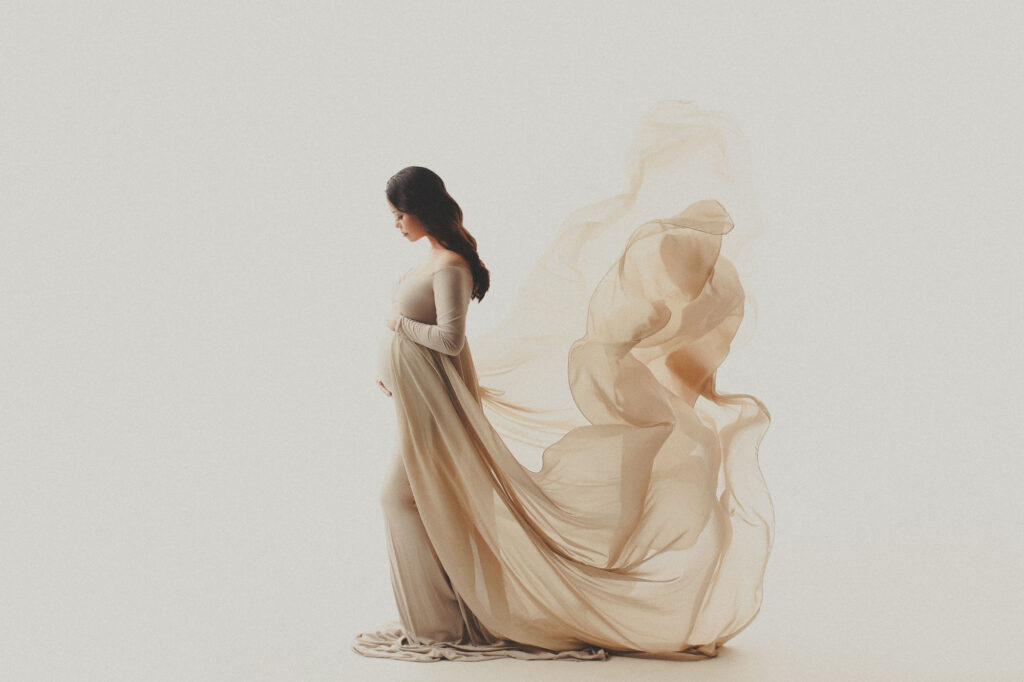 a pregnant woman in a long dress - maternity gown