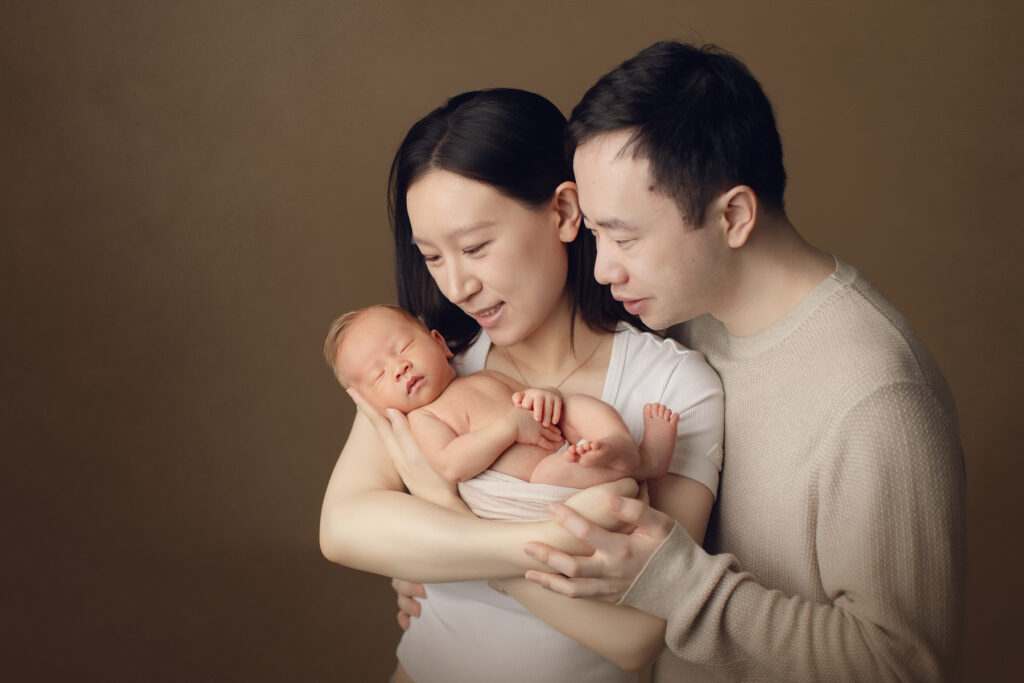 parents holding newborn in studio - Vancouver photographer