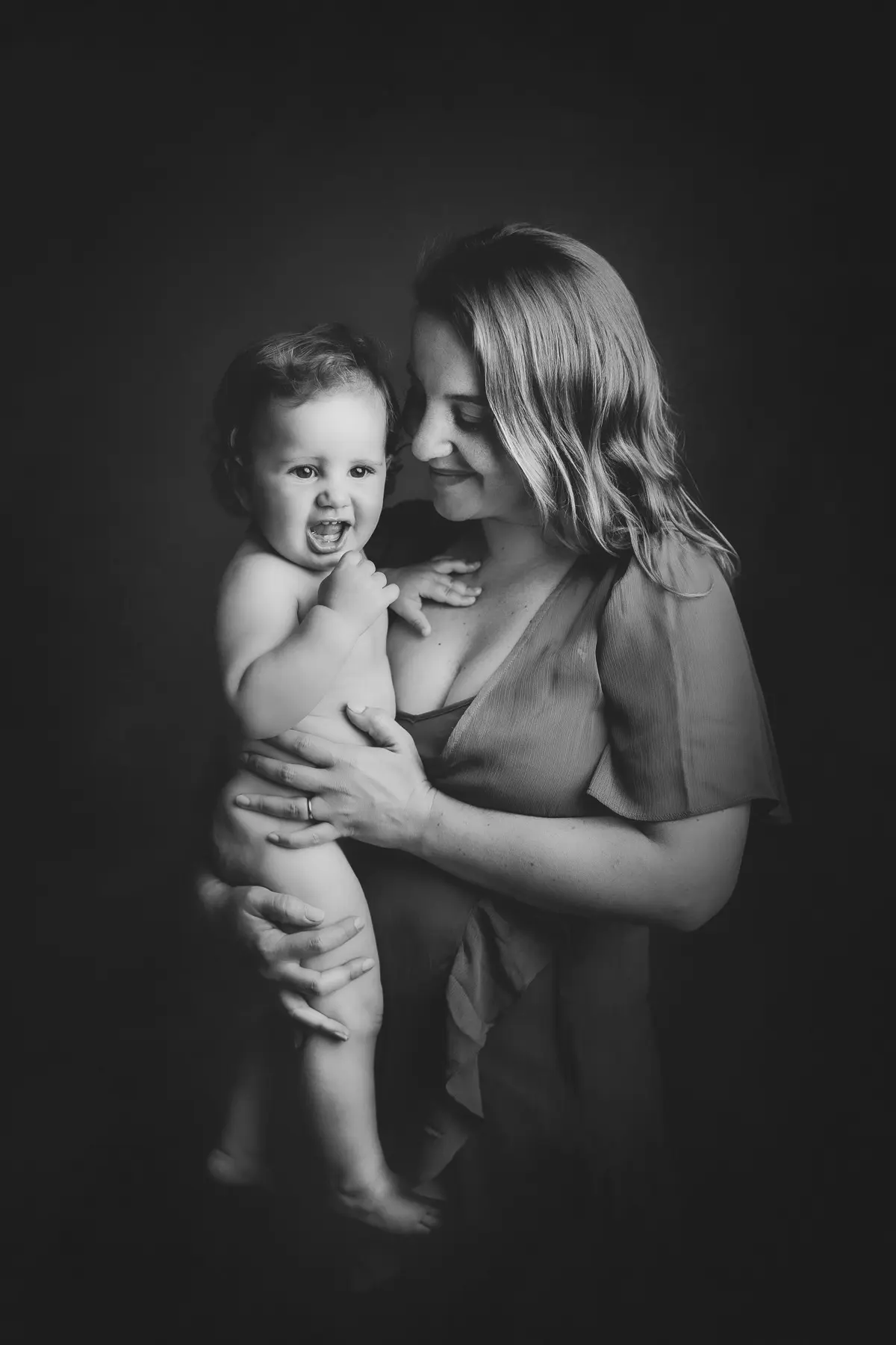 Mother holding smiling baby in portrait