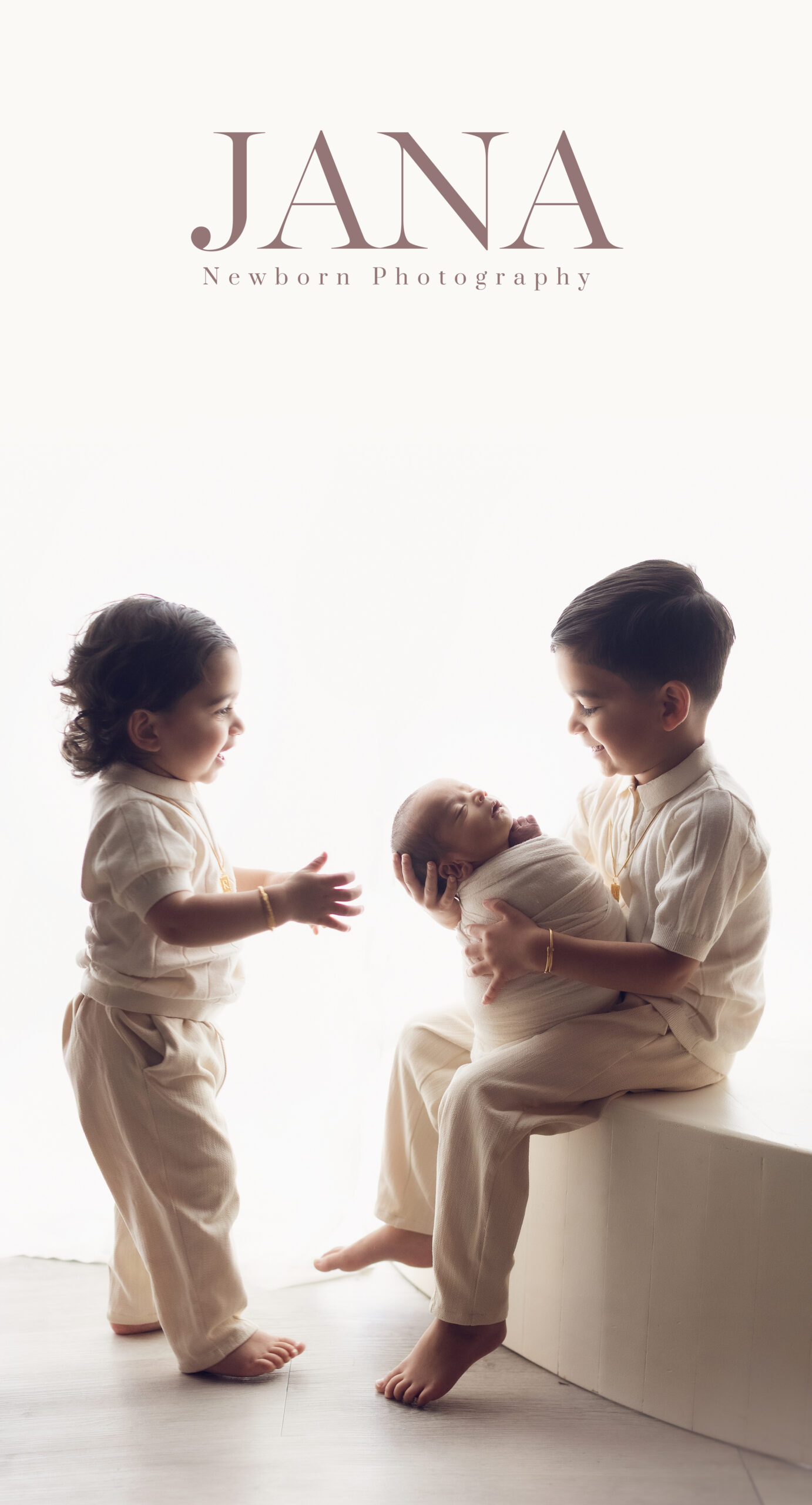 Two children with a newborn baby
