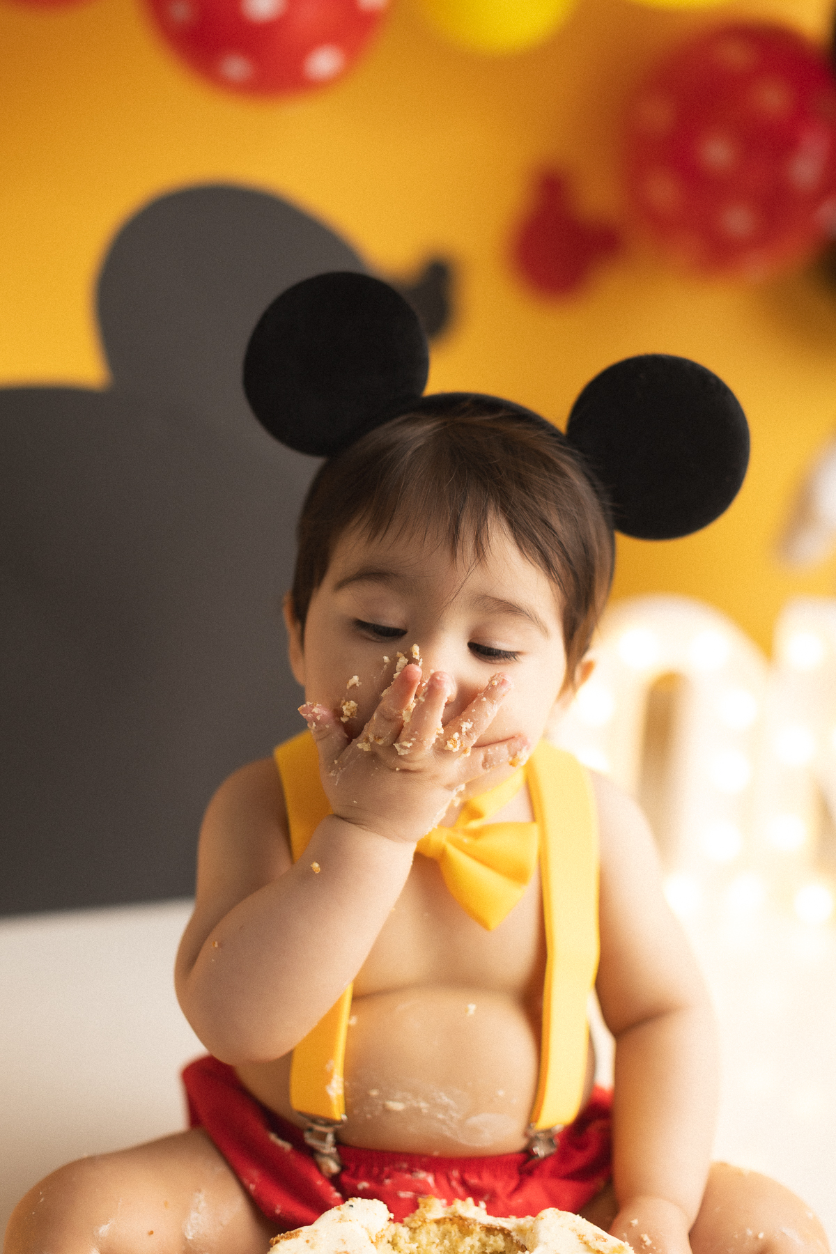 Child enjoying cake with Mickey ears