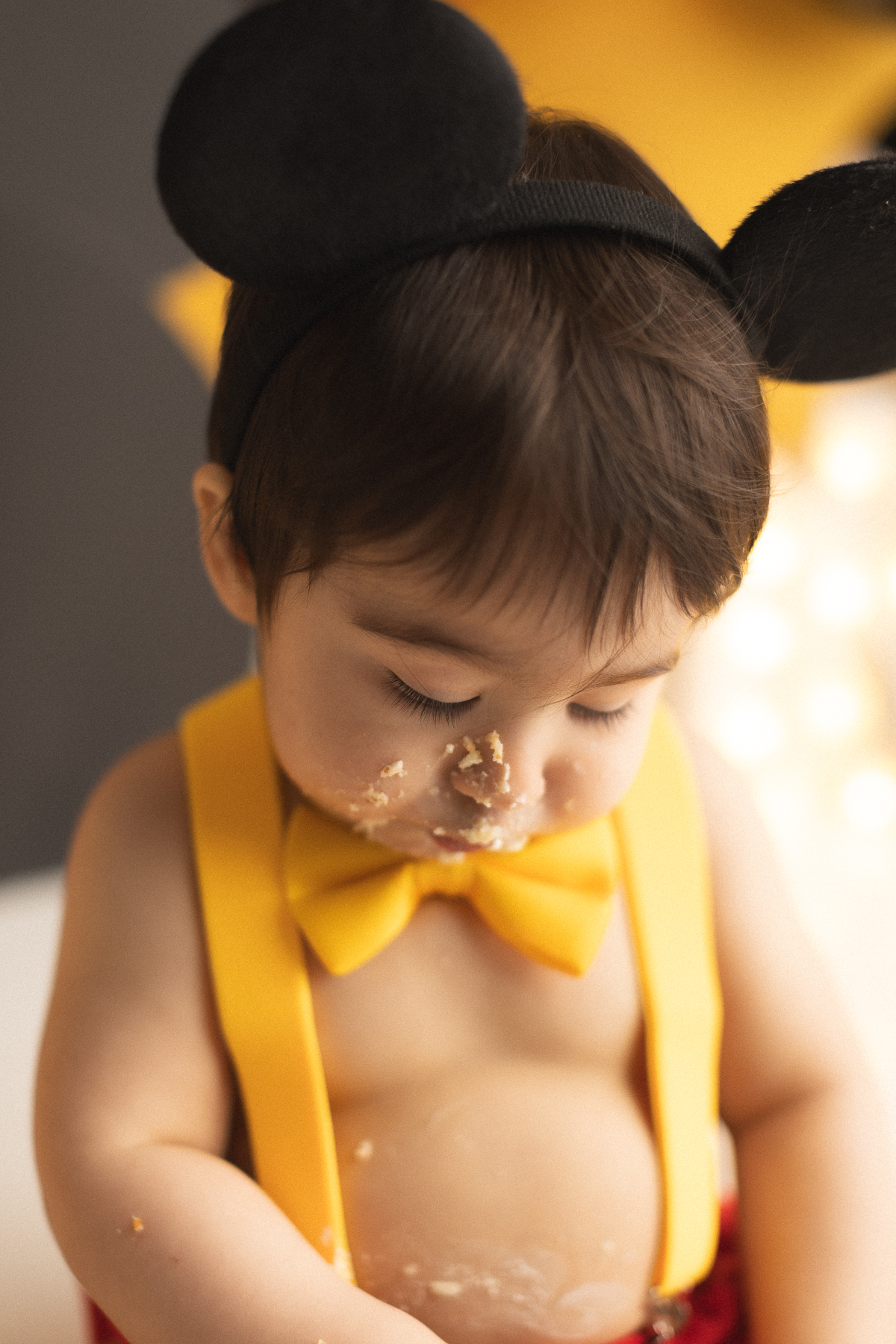 Child enjoying Mickey Mouse cake smash