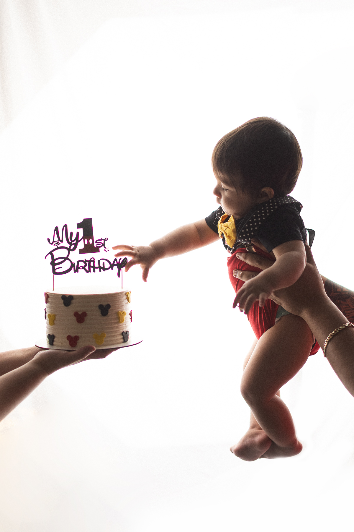 Baby reaching for birthday cake