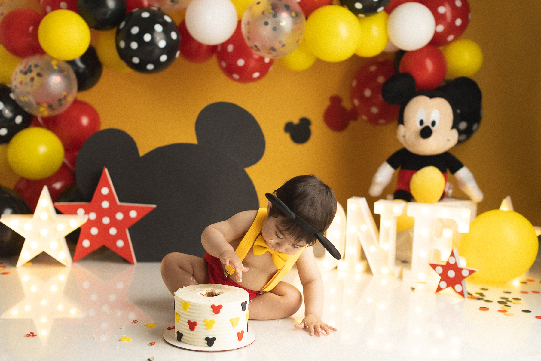 Baby enjoying Mickey Mouse cake smash