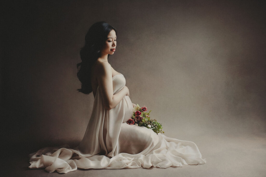 Pregnant woman holding flowers, serene