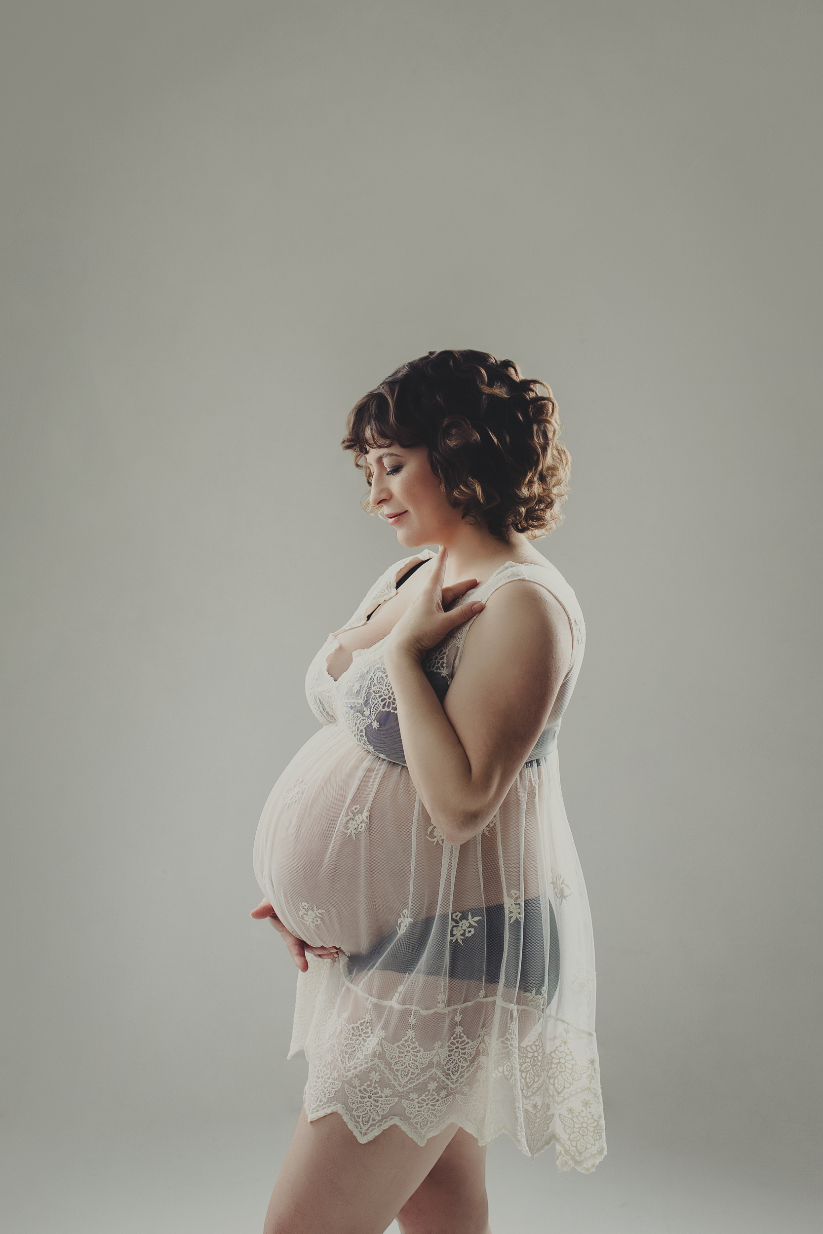 Solo maternity photoshoot in Vancouver with soft studio lighting and luxury maternity dress